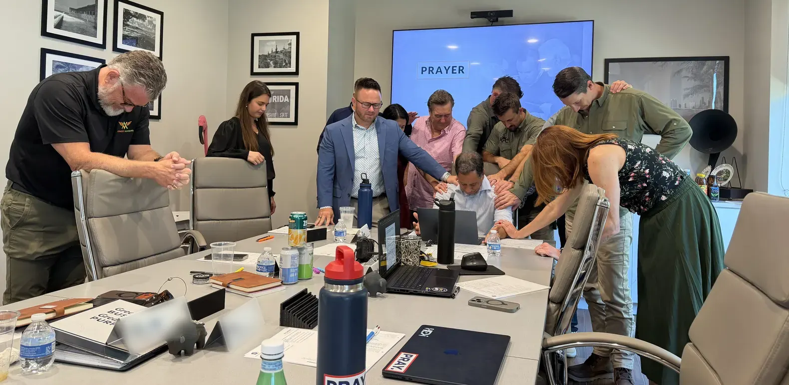 C12 South Florida forum members praying together around a conference table